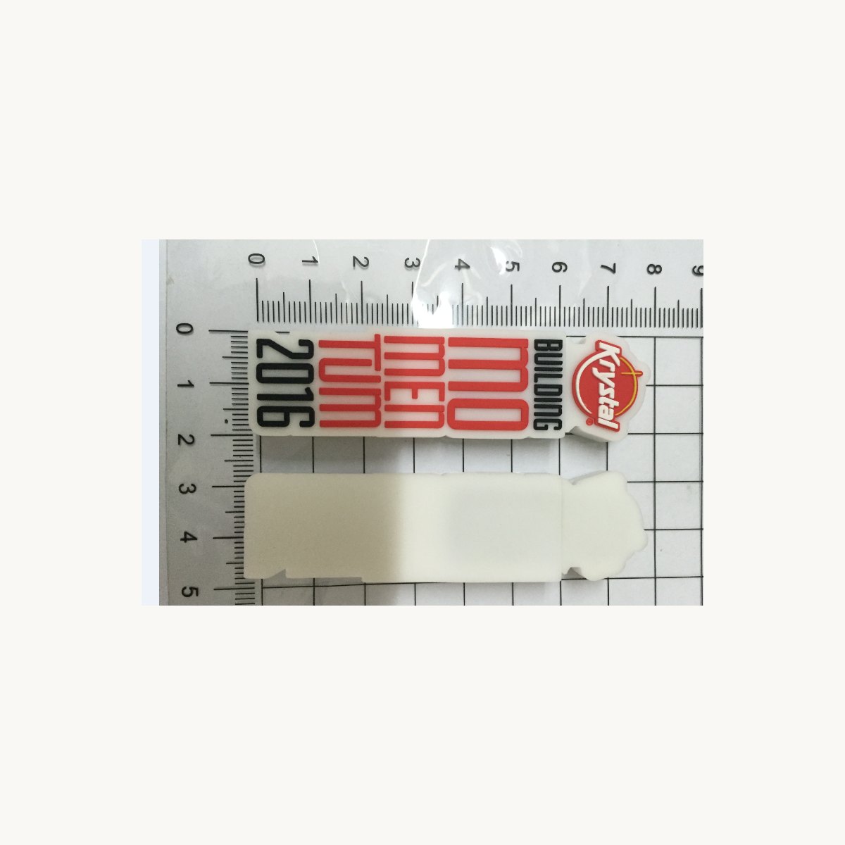 Printed soft PVC card and a blank white tag photographed with a ruler