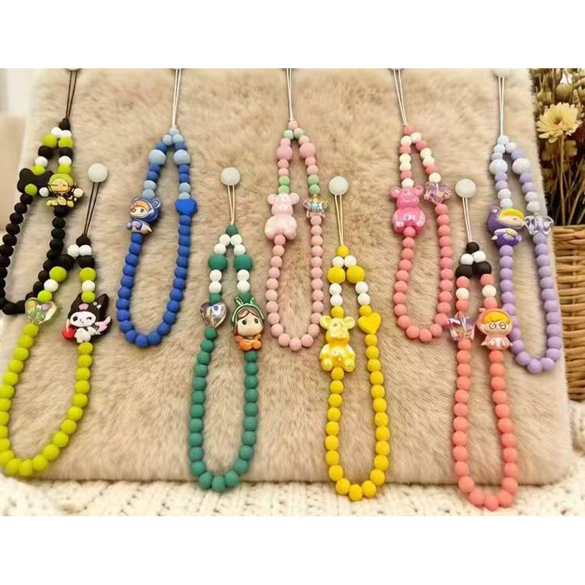Moulded silicone beads and tassels laid out as components of a custom damper bead charm