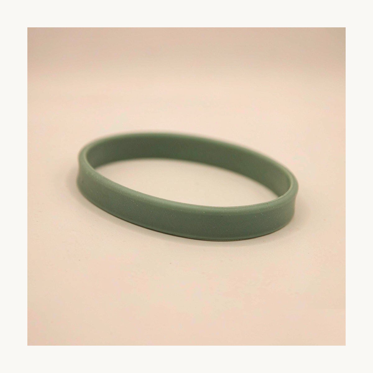 Close-up of a blank sage green food-grade silicone wristband